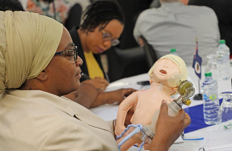Conference participant looking at model of a baby