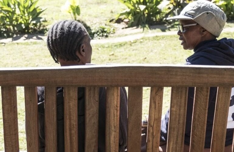 people seated in a bench talking