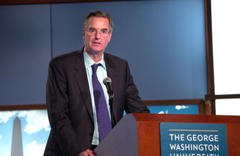 Dr. Anderson speaks behind a podium at GWU