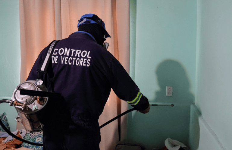 Inspector de salud durante la práctica de rociado dentro de una vivienda