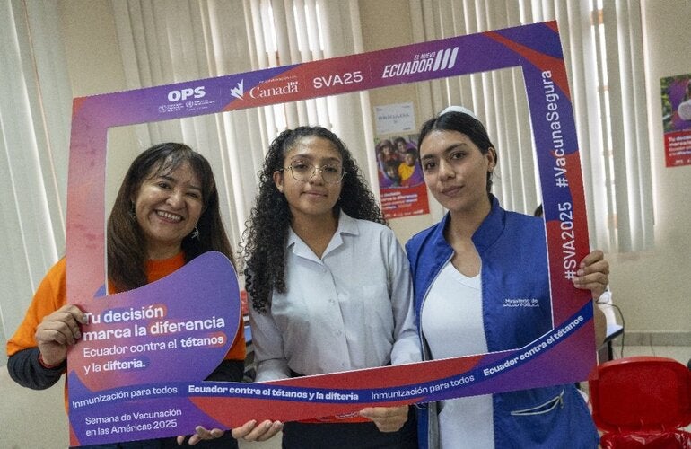 Sonia Quezada, representante de la Organización Panamericana de la Salud / Organización Mundial de la Salud (OPS/OMS) en Ecuador promueve la jornada de vacunación junto a una estudiante y una enfermera en el punto de vacunación desplegado en la Unidad Educativa “Manuela Cañizares”. 