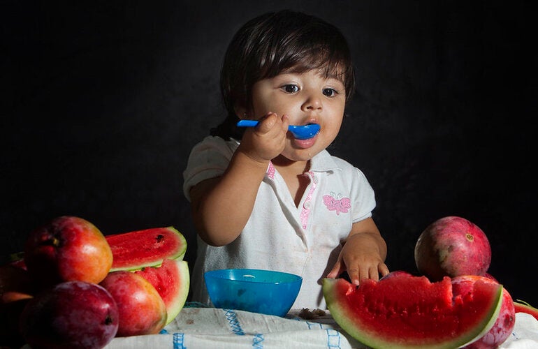 criança comendo melancia