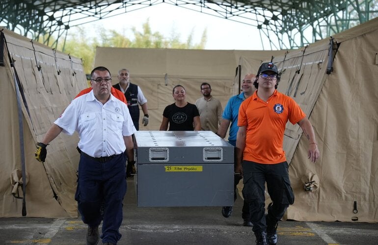 Miembros de los EMT movilizando un contenedor con elementos de uno de los módulos