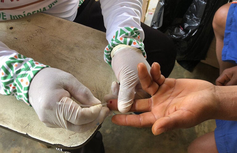 Health worker pricking finger to get a drop of blood to test for hepatiti