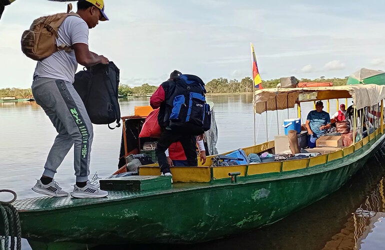 Trabajadores sanitarios abordan la embarción en Puerto Samariapo rumbo al municipio Alto Orinoco para atender a comunidades yanomami