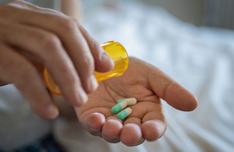 Woman holds antibiotics on her hand