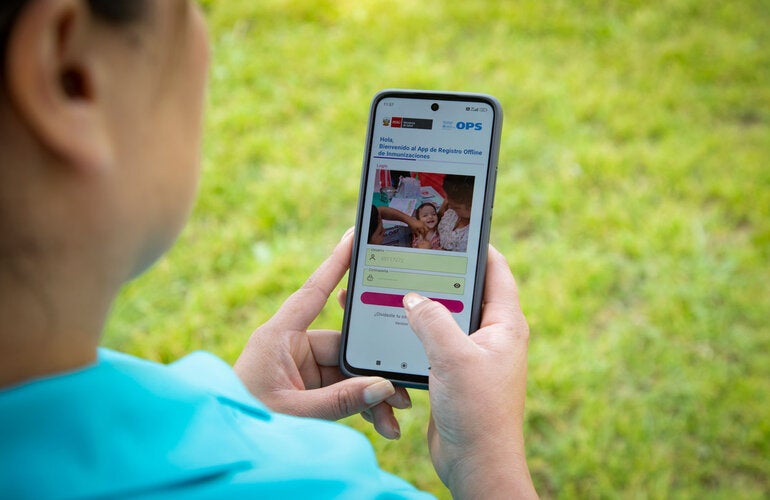 Person holding a mobile phone with immunization's application