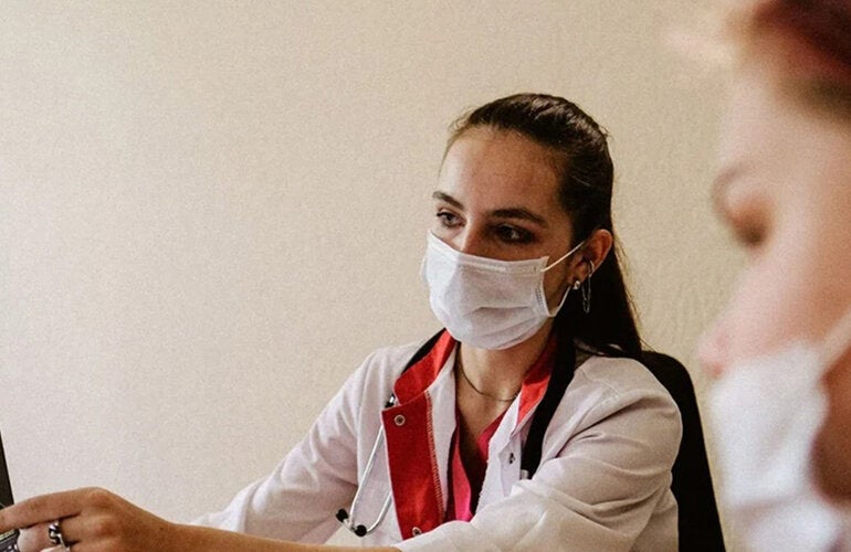 Médica mostrando resultado de exame de pulmão para paciente