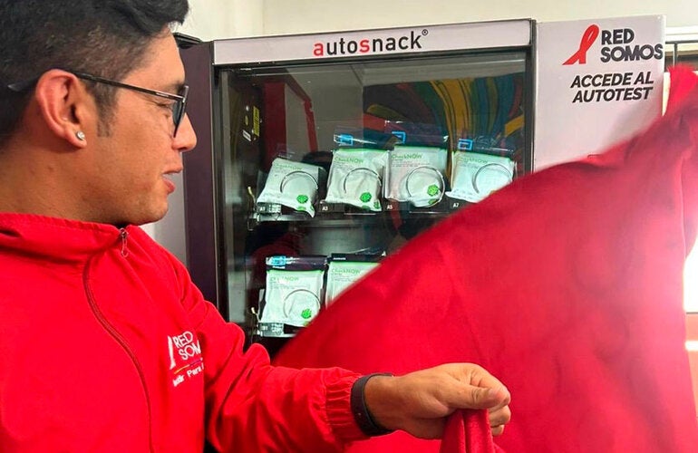 Personaje destapando maquina dispensadora de pruebas de tamizaje