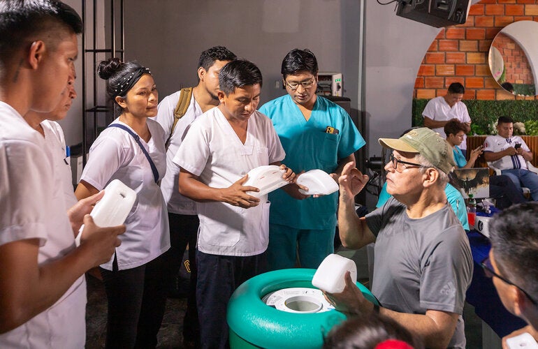 Personal de salud practica cómo colocar los paquetes congelantes en la caja fría pasiva de larga duración.