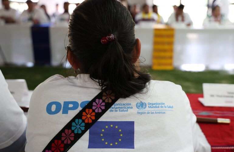 Mujer de espalda participando en reunión sobre salud materna