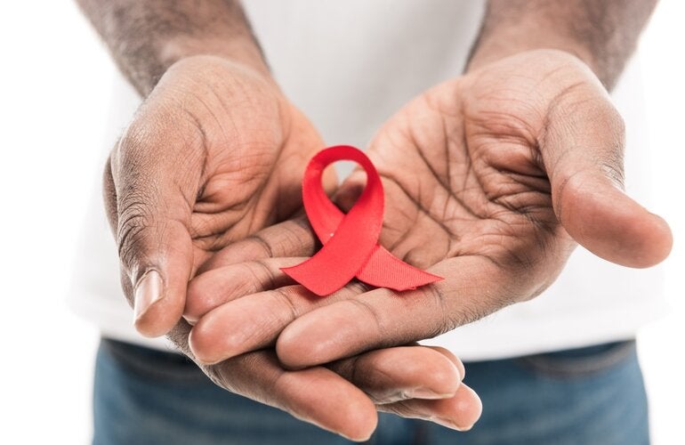 Un hombre sostiene la cinta asociada con el VIH