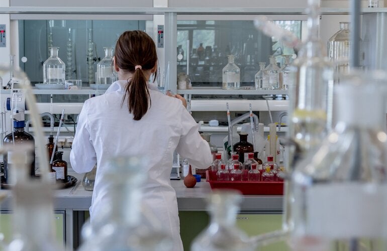 Woman backing camera in laboratory.