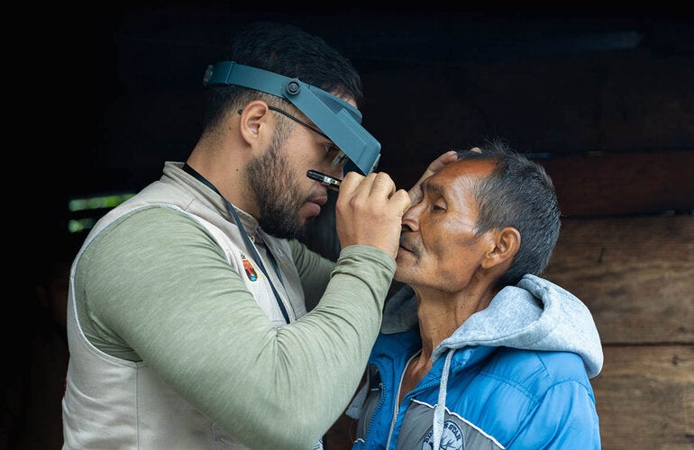 Trabajador de salud revisando los ojos de un paciente