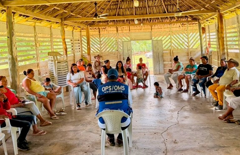 personas indigenas escuchando a personal de OPS
