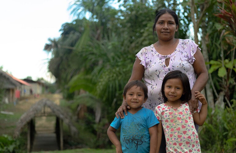 A mother in the Amazon with her smiling daughter and son