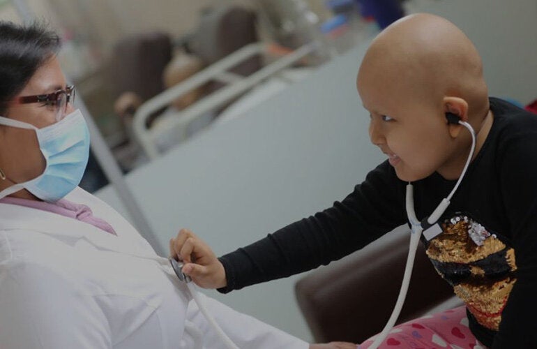 child with cancer interacting with doctor