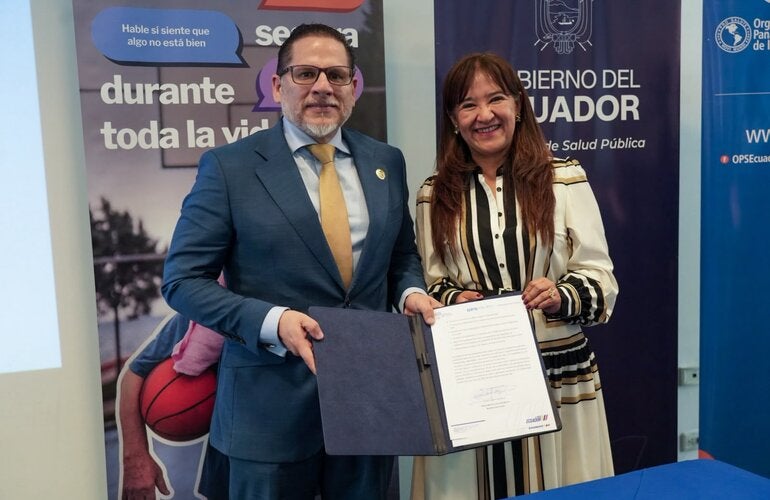 Ministro de Salud Pública, Juan Carlos Aveiga, junto a Sonia Quezada, representante de OPS/OMS Ecuador; muestra documento de Adhesión a la Iniciativa "Mejor Atención a las Enfermedades No Transmisibles".