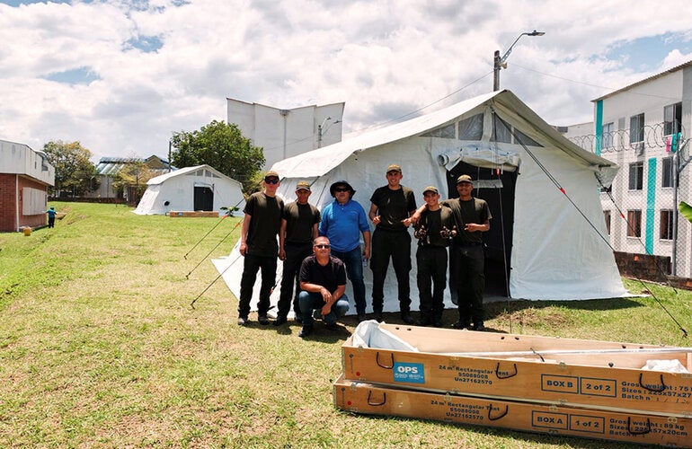 personas posando con una carpa detras