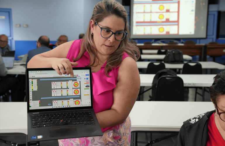 Participante del taller mostrando la herramienta de trabajo grupal