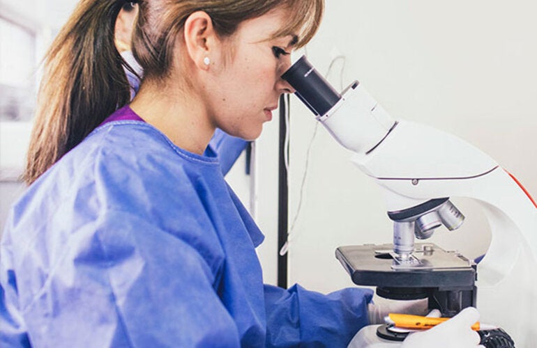 Woman seeing through a microscope