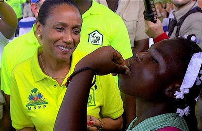 Photo:  PAHO/WHO, D. Spitz. Minister of Health of Haiti, Daphnée Benoit Delsoin, applies the first dose of the oral vaccine of cholera to a student in Les Cayes, Haiti.