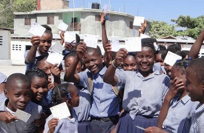 children holding up their vaccination cards