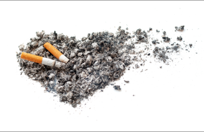 Imagen de una colilla apagándose en un conjunto de ceniza con forma de corazón. A la derecha, parte del corazón de ceniza se deshace