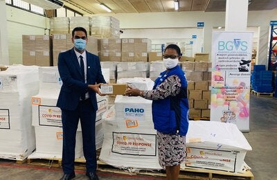 Dr. Karen Lewis-Bell, PAHO/WHO Representative in Suriname hands over a donation of COVID-19 supplies for case management to Dr. Amar Ramadhin, Minister of Health