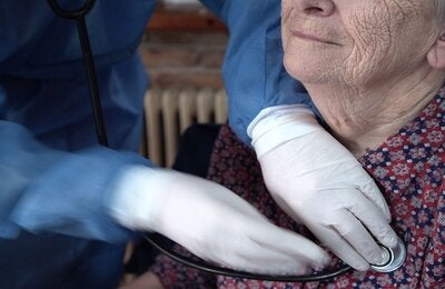  Un miembro del personal de la clínica ayuda a una mujer mayor.