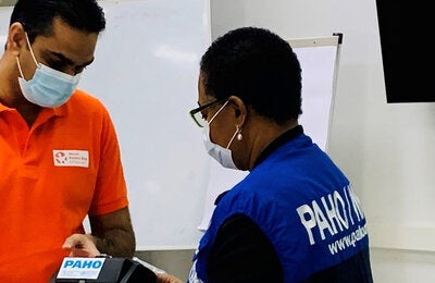 Minister Ramadhin and Dr. Lewis-Bell inspect the biPAP machines at the official handover