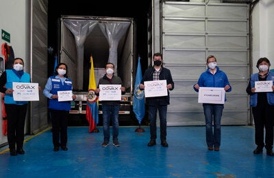 Personal de Entrega de Vacunas con letreros de COVAX