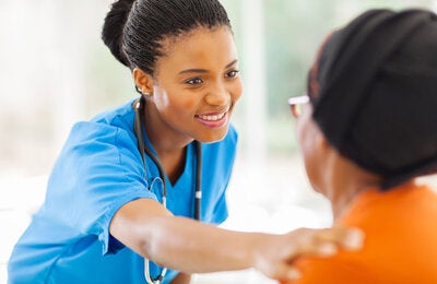 Nurse reaching out to comfort older patient