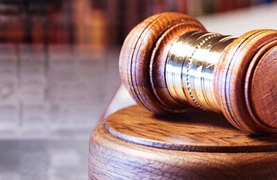 Resting gavel with cigarette packaging in the background