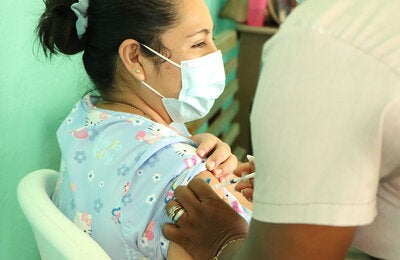 Mujer jóven recibe vacuna contra la COVID-19
