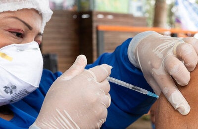 Health worker applies COVID-19 vaccine