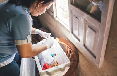 Muestra y diagnóstico desde casa: Una trabajadora del Ministerio de Salud de Colombia, se prepara para obtener muestras de sangre de una persona enferma de dengue.