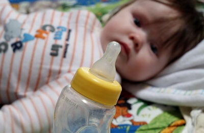 Bebé con biberón con fórmula