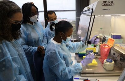 (L-R)  Dr. Valeska Stempliuk, Valeska Stempliuk - Advisor, Health Surveillance, Disease Prevention and Control, PAHO/ WHO Office for Jamaica, Bermuda & The Cayman Islands;  Dr. Michelle Hamilton, Director of the National Public Health Laboratory and Dr. Lionel Gresh, Virologist at PAHO Headquarters in Washington looks on as Ms. Cindy Thomas, Senior Medical Technologist at the National Public Health Laboratory conducts a diagnostic test on the Monkeypox virus.