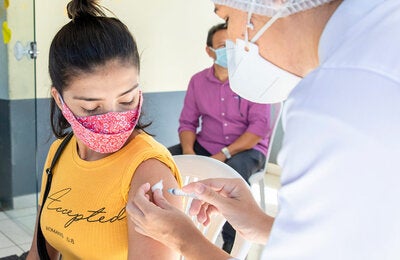 Mujer jóven recibe vacuna