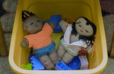 Two dolls in a plastic container