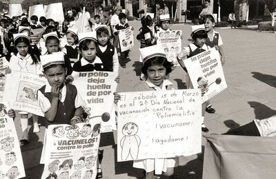 © WHO Mexico | 1986. School children march through the streets of Mexico on National Vaccination Dayarrying banners in favour of polio immunization. PHOTO: Liba Taylor.