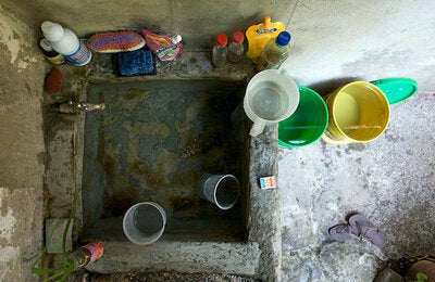 A community health officer visits a house to educate the owner and check water storage to control mosquito breeding sites, Colombia. PAHO/WHO, J Dempster