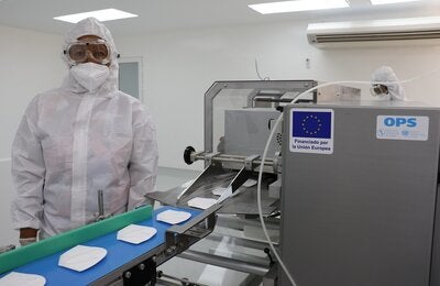 Operaria trabaja en línea de mascarillas