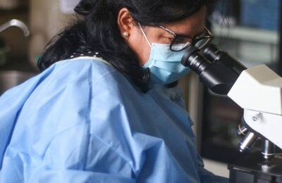 Dr Roxana Castillo at a microscope