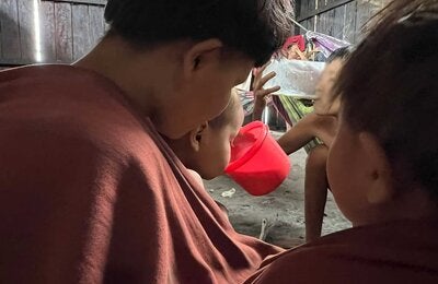 Criança Yanomami bebendo o leite terapêutico