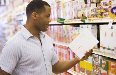 Man looking at front of package labels.