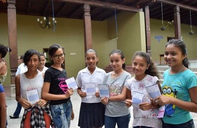 Niñas mostrando carnet de vacunación VPH
