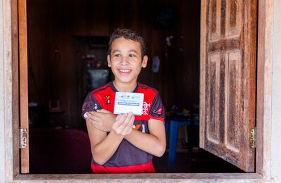 Menino vacinado com a caderneta de vacinação na mão
