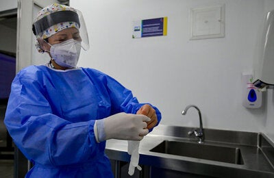 Trabajadora de salud se pone guantes
